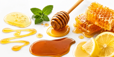 Flat bottom spout pouch of raw honey beside a wooden honey dipper and honeycombs